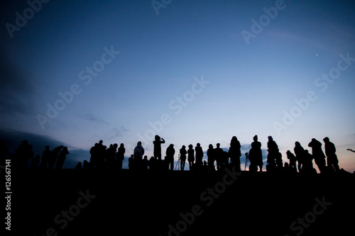Silhouette of a group of people waiting for sun rise at the mountain peak with dramatic sky, Thailand