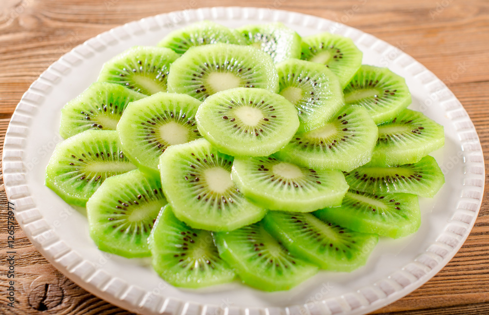 Fresh organic sliced kiwi on white plate, selective focus Fresh organic sliced kiwi on white plate, selective focus