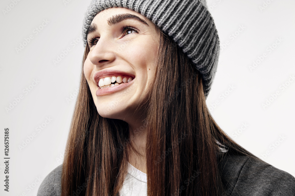 Young pretty beautiful woman in a grey outfit. Closeup portrait of smiling face. Winter clothes. Young pretty beautiful woman in a grey outfit. Closeup portrait of smiling face. Winter clothes.