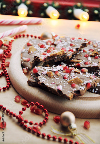 Christmas dessert food idea - festive chocolate with pomegranate seeds  gingerbread cookie and christmas candy cane  selective focus