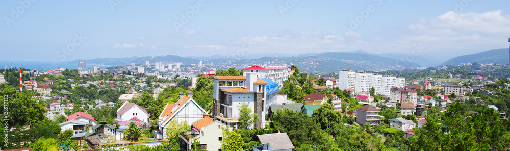 The small town is on the background of the mountain range, the landscape. City, mountain and blue sky are in Russia, Sochi. 