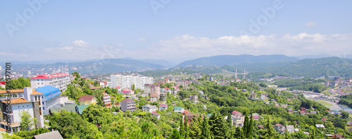 The small town is on the background of the mountain range, the landscape. City, mountain and blue sky are in Russia, Sochi. 