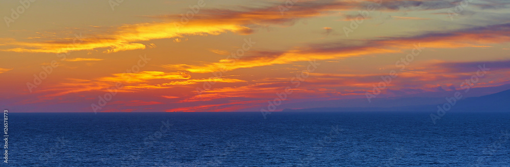 The Pacific Ocean is during sunset. Landscape with blue sea, the mountains and the dusk sky, the USA, Santa Monica. 