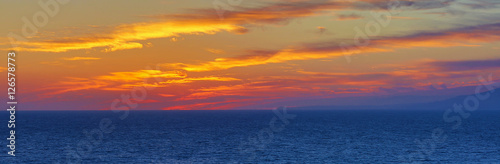 Fototapeta Naklejka Na Ścianę i Meble -  The Pacific Ocean is during sunset. Landscape with blue sea, the mountains and the dusk sky, the USA, Santa Monica. 