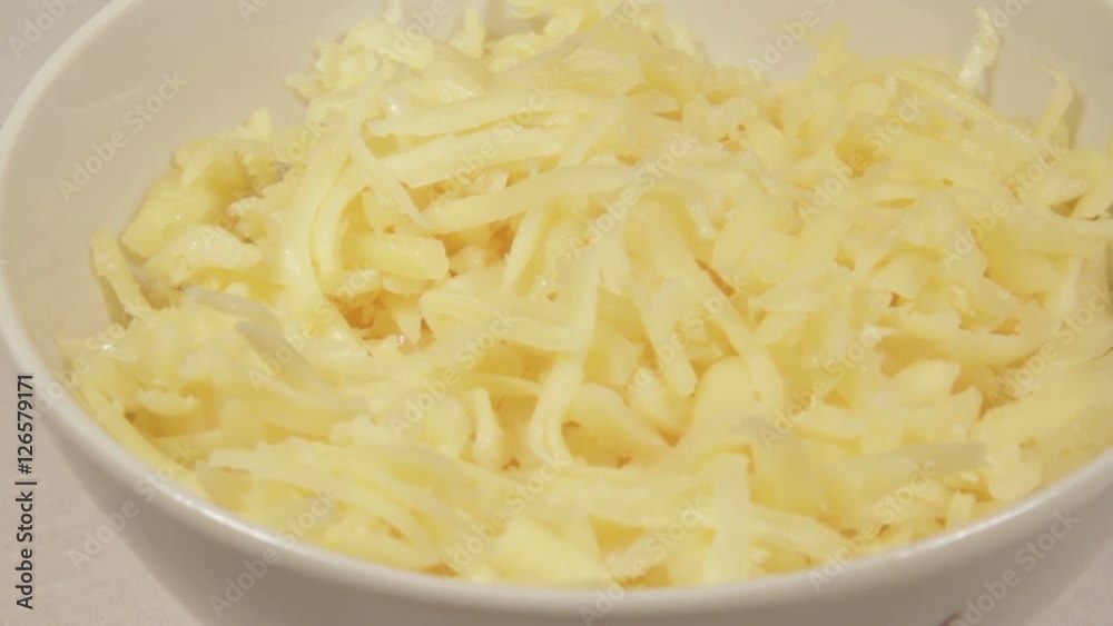 Grated cheese in a bowl. Rotation. Grated cheese in a bowl. Rotation.