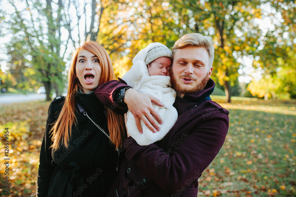 Fototapeta premium young family and newborn son in autumn park