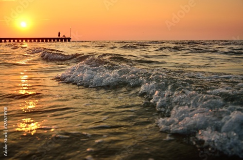 Wave on the calm sea in Italy near by beach with old fisherman during wonderful and colorful summer sunset © kovop58