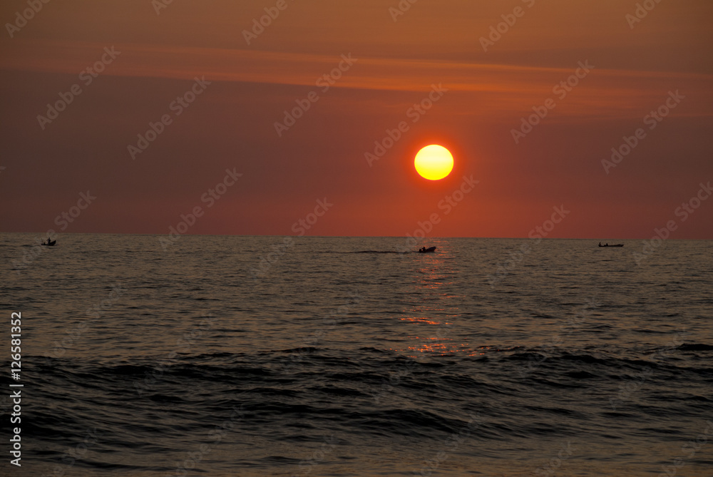Guatemala. pacific ocean. Silhouette of the fisherman or leisure boat sailing toward golden sunset with saturated sky and clouds. Beautiful seascape in the evening.