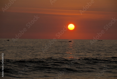 Guatemala. pacific ocean. Silhouette of the fisherman or leisure boat sailing toward golden sunset with saturated sky and clouds. Beautiful seascape in the evening.