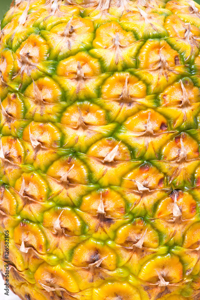 Macro photo of the texture  pineapple peel in the sun. Yellow flakes.