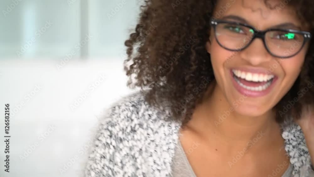 Portrait of cheerful mixed-race woman putting eyeglasses on Portrait of cheerful mixed-race woman putting eyeglasses on