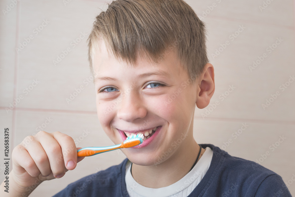 Smiling boy cleans teeth Smiling boy cleans teeth