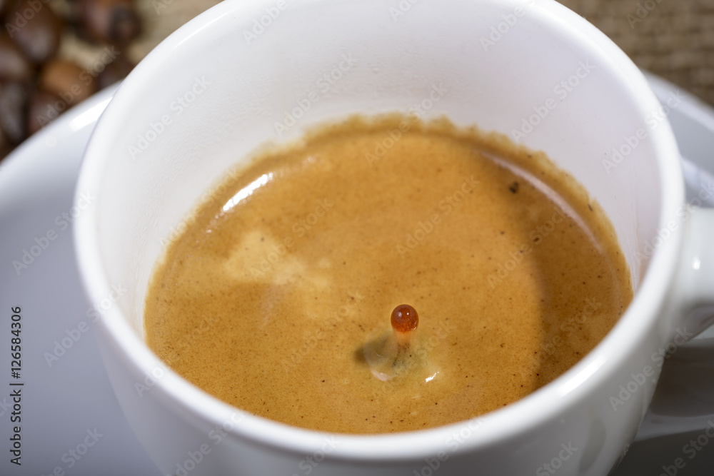 macro drop of coffee in fall toward the cup of coffee macro drop of coffee in fall toward the cup of coffee