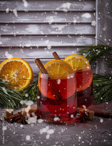 Glasses of mulled wine with orange and cinnamon  snow effect