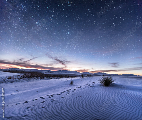 Sand dunes with footprints in the desert under night sky, New Mexico
