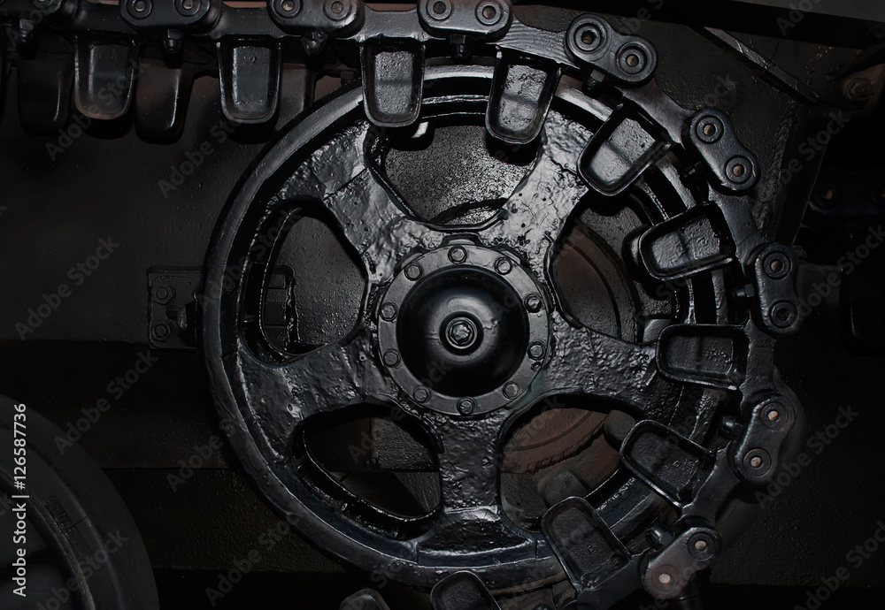 Black & white photo of an armored war battle tank wheel & caterpillar profile view on dark background. Black & white photo of an armored war battle tank wheel & caterpillar profile view on dark background.