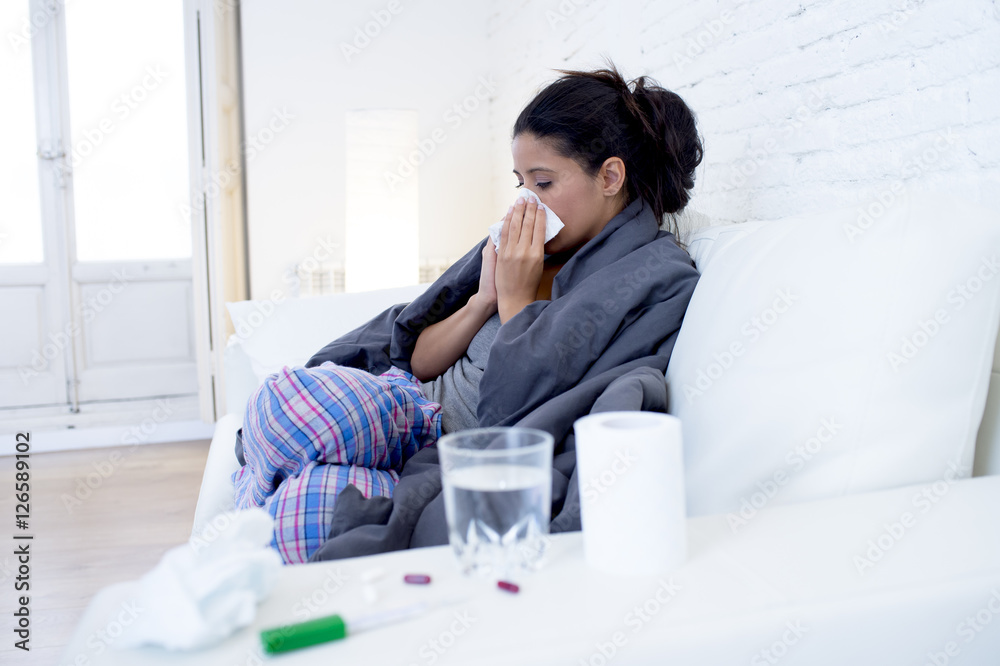 young attractive hispanic woman lying sick at home couch in cold and flu in gripe disease symptom young attractive hispanic woman lying sick at home couch in cold and flu in gripe disease symptom