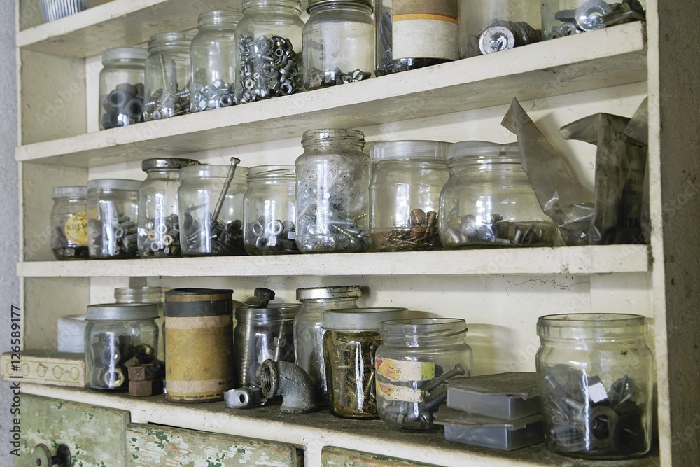 Various vintage old jars with metal bolts, nuts and screws