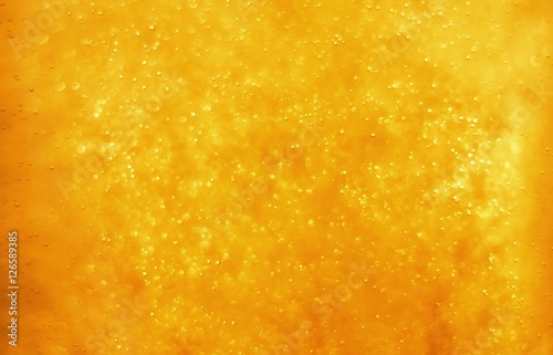 Bubbles floating in the liquid orange drink, abstract image.