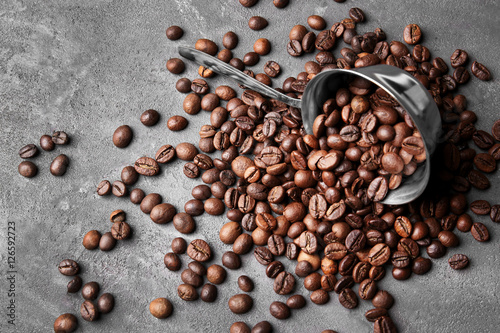 Coffee beans with cezve on grey background