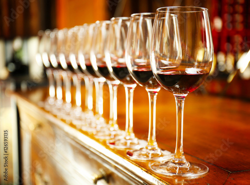 Row of glasses with red wine on bar counter