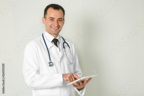 Doctor with tablet on color...