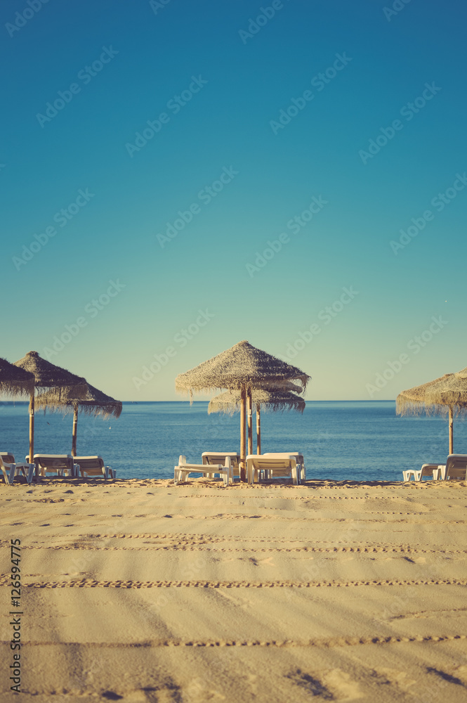 Beach umbrella chairs on the sunny blue sky beach outdoors background