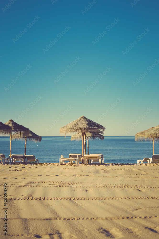 Beach umbrella chairs on the sunny blue sky beach outdoors background Beach umbrella chairs on the sunny blue sky beach outdoors background
