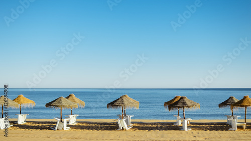 Beach umbrella chairs on the sunny blue sky beach outdoors background