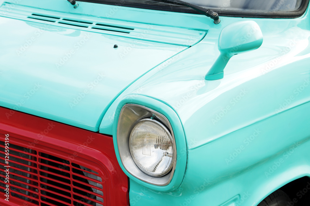 Turquoise vintage car on a festival of old cars. Retro car's headlight close up.