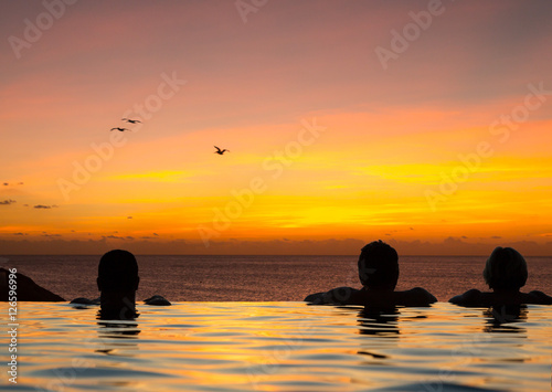 Infinity edge pool with sea underneath sunset © steheap