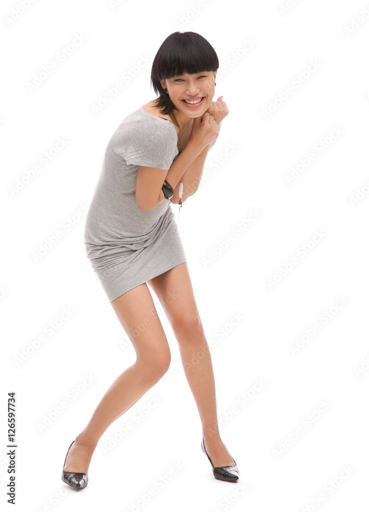 Young woman standing against white background, smiling at camera Young woman standing against white background, smiling at camera