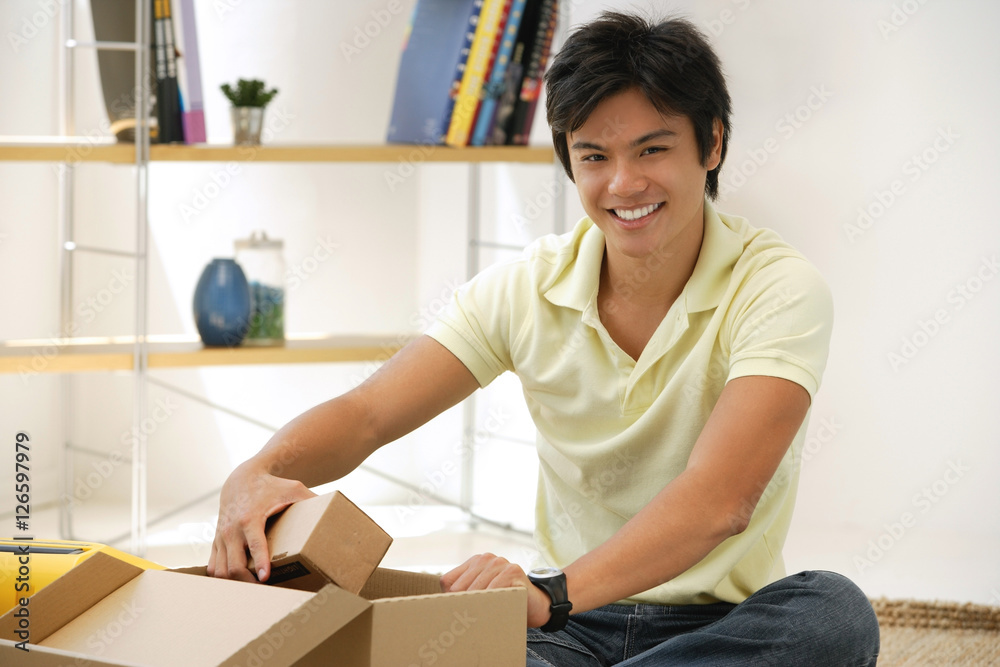 Man sitting with box, smiling at camera Man sitting with box, smiling at camera