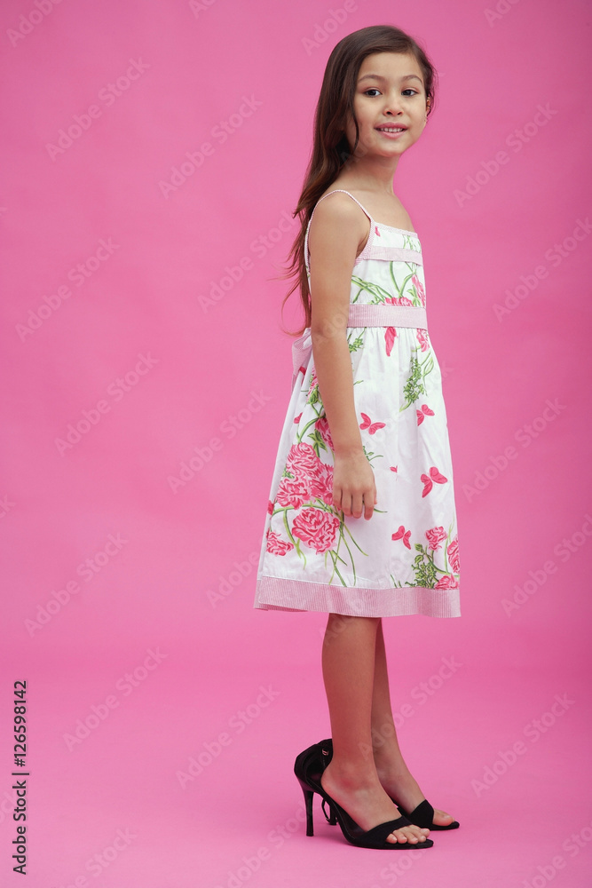 Young girl wearing high heel shoes, looking at camera Young girl wearing high heel shoes, looking at camera