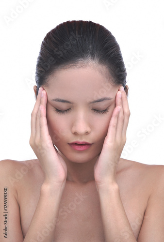 Young woman with hands on head, eyes closed