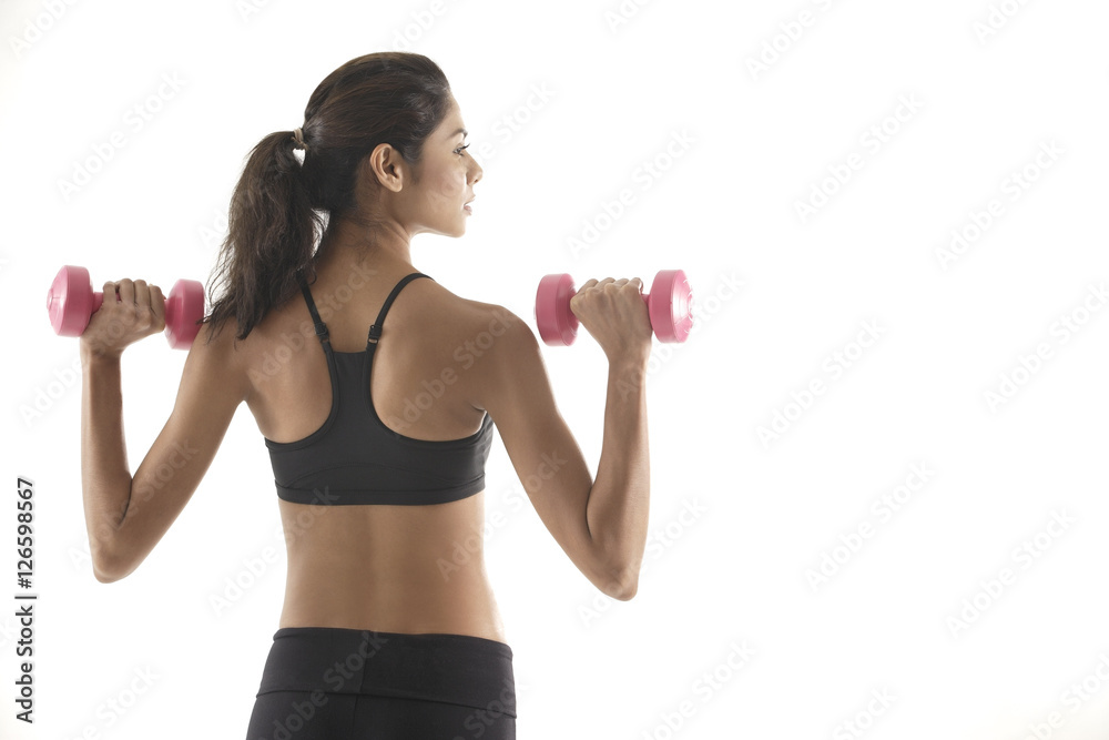 Woman with back to camera, lifting weights, working out