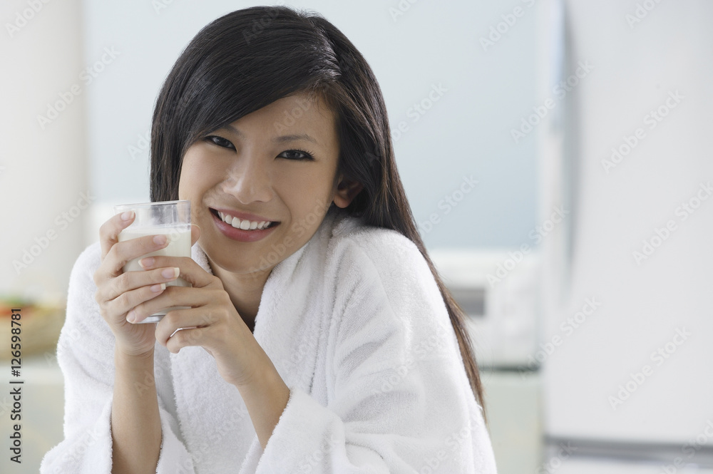 woman in kitchen, holding glass of milk, smiling at camera woman in kitchen, holding glass of milk, smiling at camera