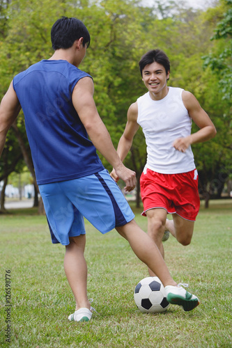 Two men in park, playing soccer