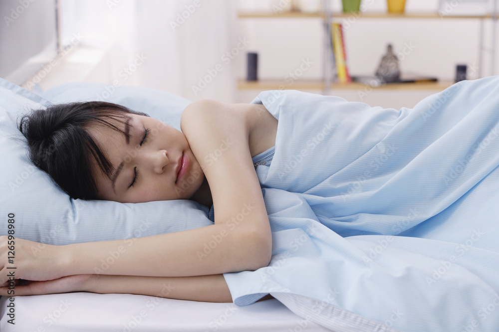 Young woman sleeping in bed