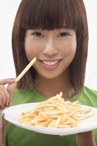 Young woman holding a plate of French fries