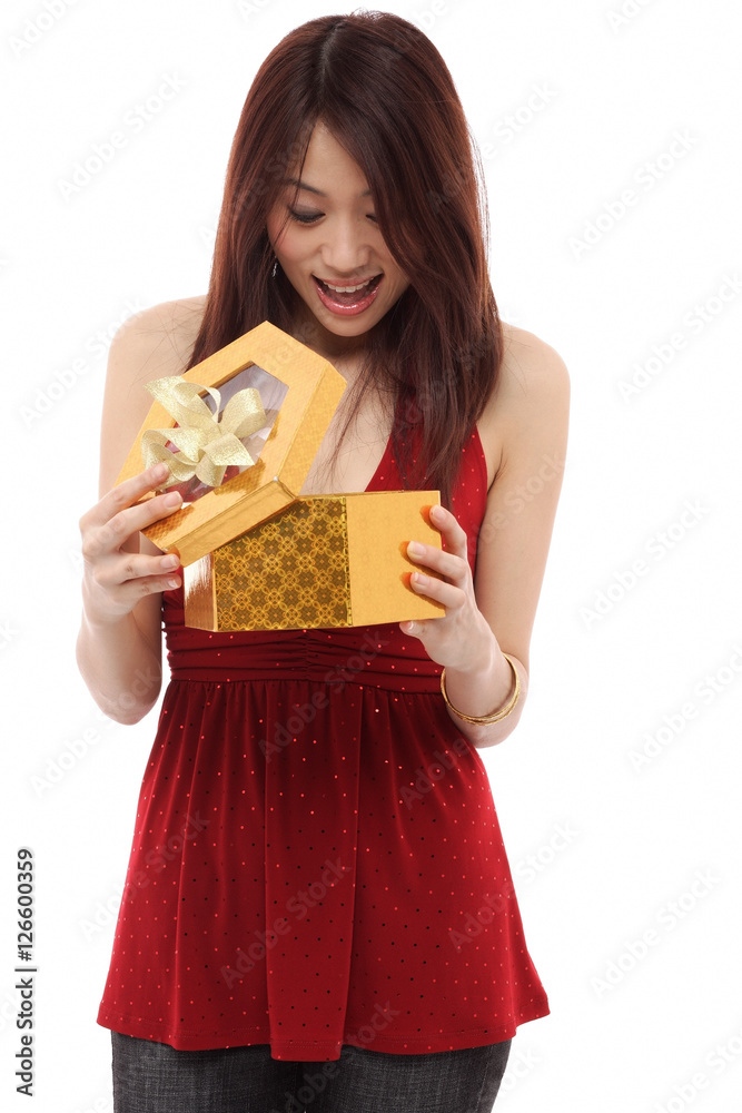 Young woman opening present and looking inside box Young woman opening present and looking inside box