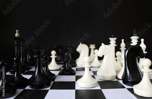 Chess game. Chess pieces against black background