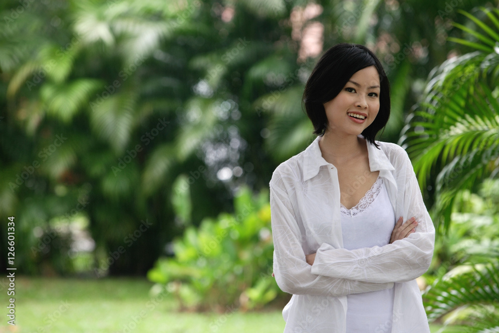 A woman in a garden smiles at the camera A woman in a garden smiles at the camera