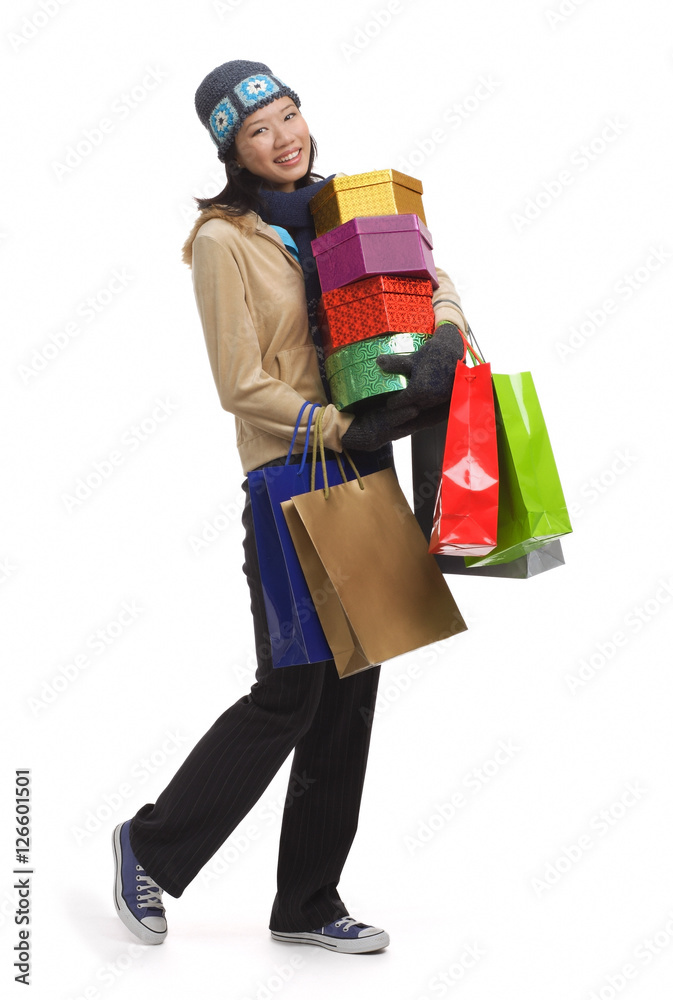 Young woman with gift boxes and shopping bags, smiling at camera Young woman with gift boxes and shopping bags, smiling at camera
