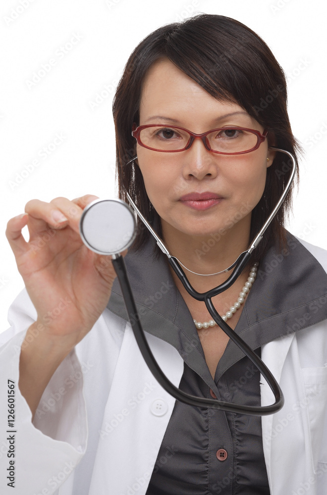 Doctor holding up stethoscope and looking at camera Doctor holding up stethoscope and looking at camera