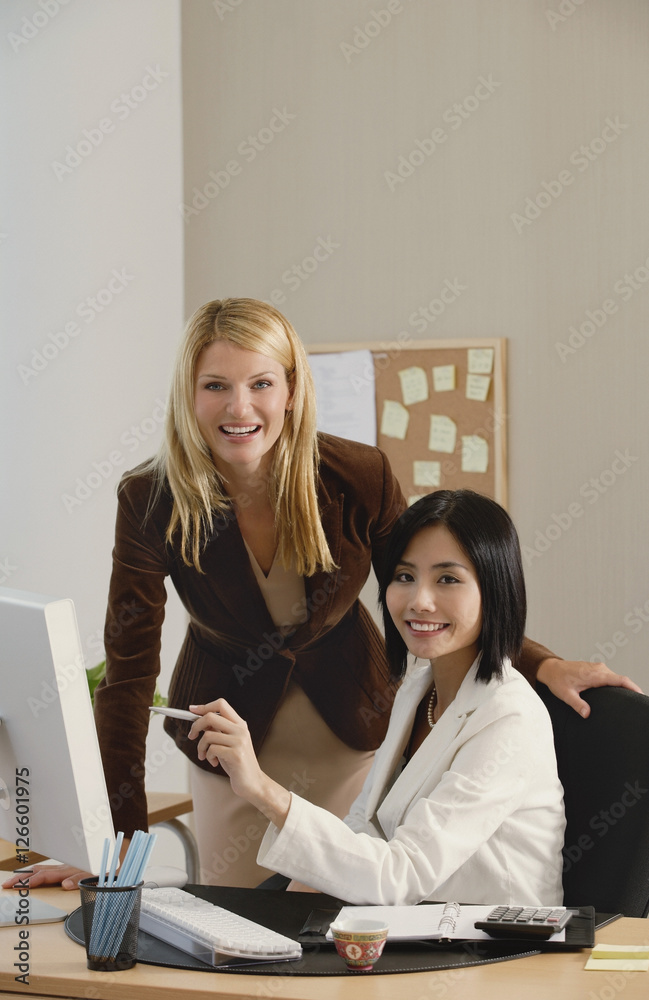Two female colleagues smile at the camera together