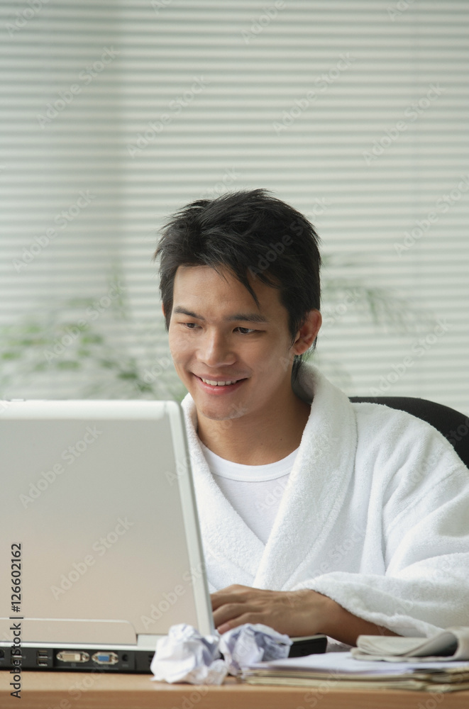 Man in bathrobe working at computer Man in bathrobe working at computer