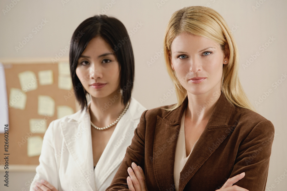 Two female colleagues look at the camera together Two female colleagues look at the camera together