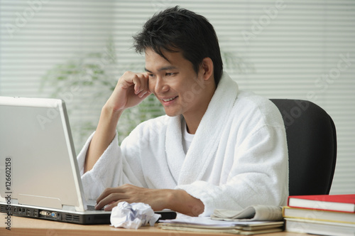 Man in bathrobe working at computer