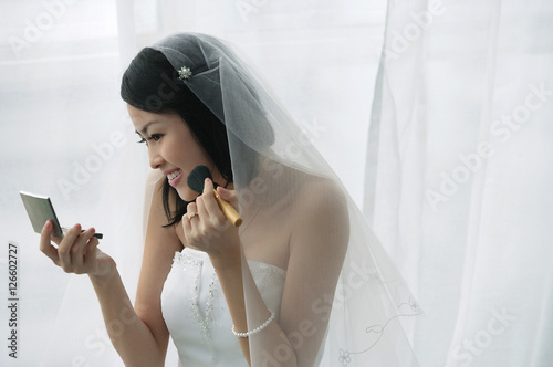Obraz na płótnie A bride does her makeup in the mirror w salonie